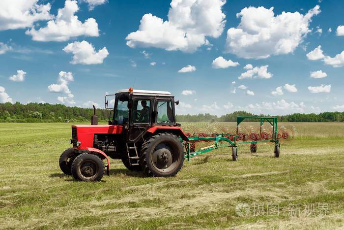 农业机械一台拖拉机在一片蓝天上收集草干草收获草收获收获季节草农地